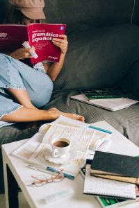 a woman sitting on the couch while reading a book