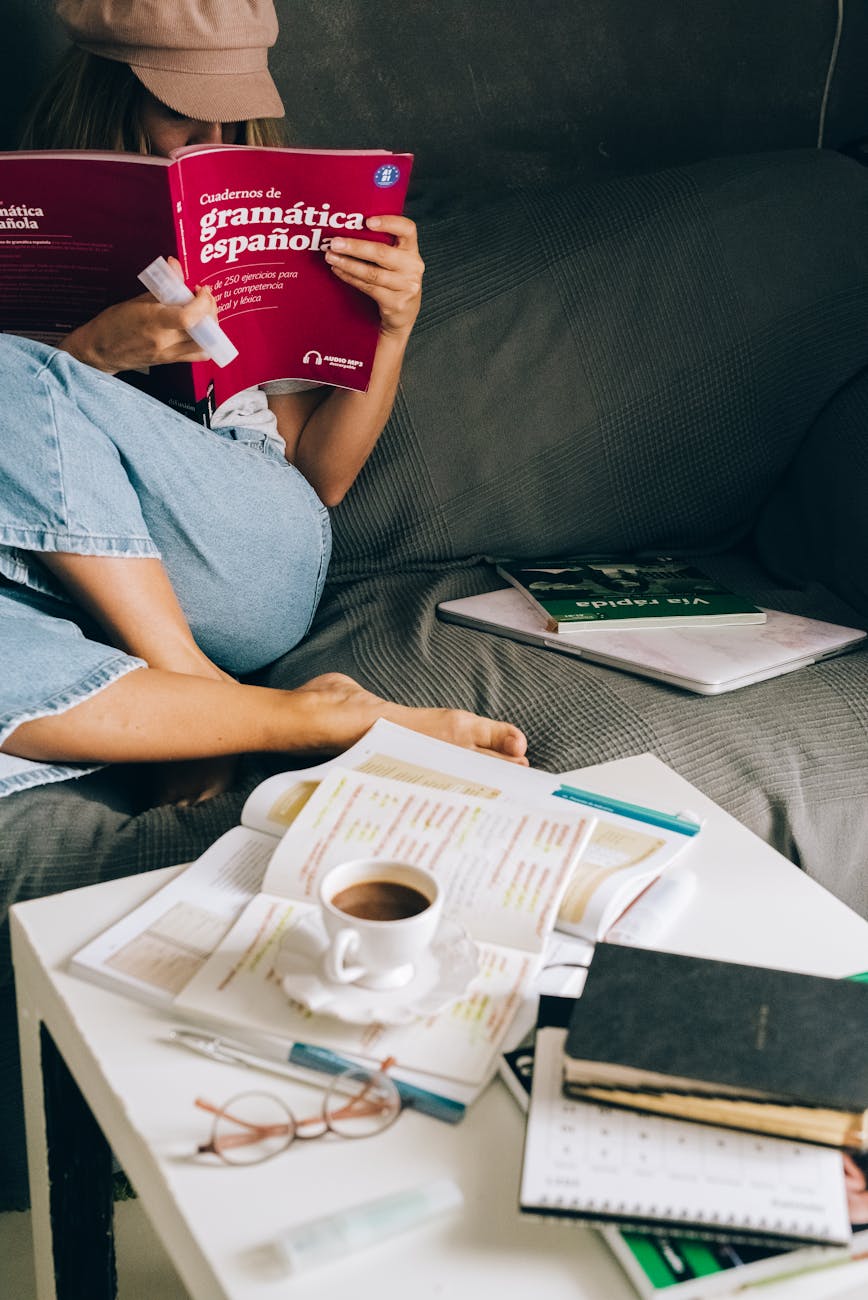 a woman sitting on the couch while reading a book