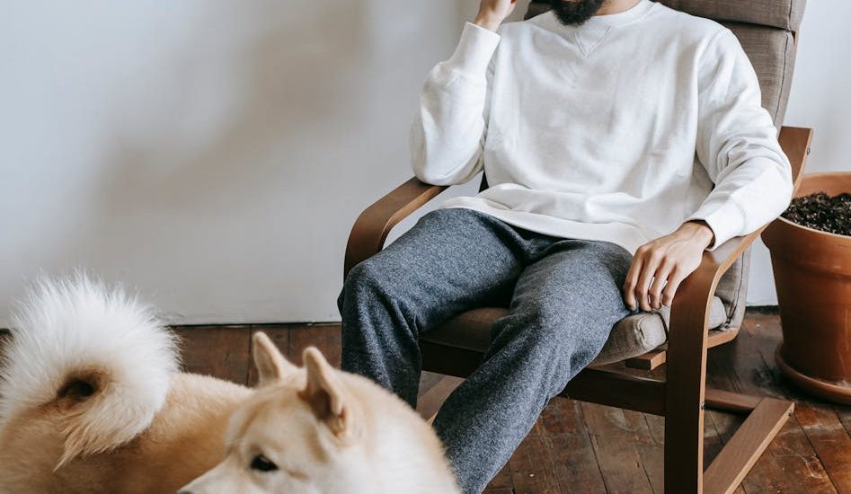 a man sitting on an armchair while talking on the phone