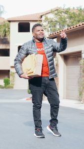 a man in gray jacket making a delivery