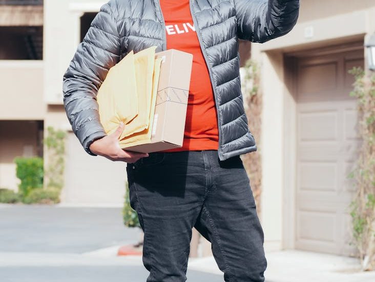a man in gray jacket making a delivery