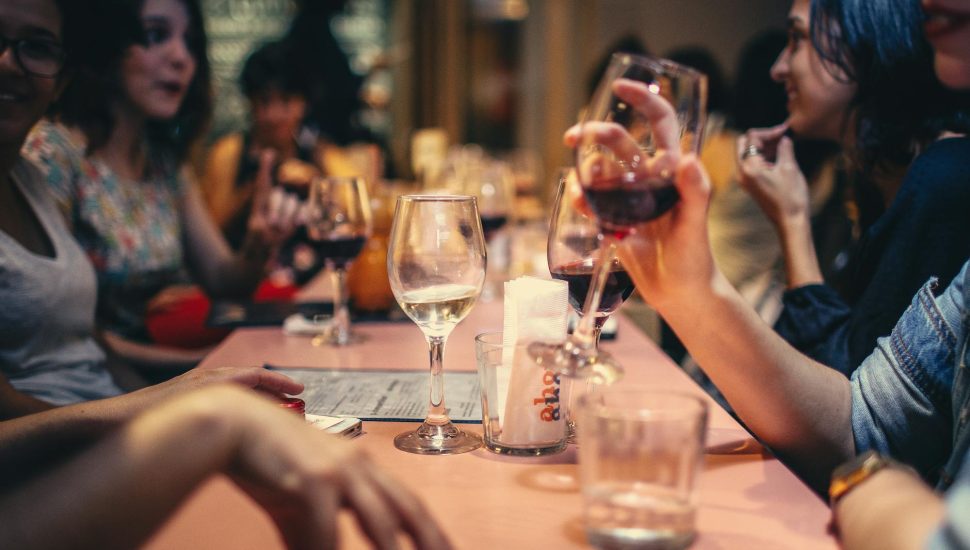 people drinking liquor and talking on dining table close up photo