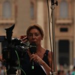 woman in red shirt holding black microphone