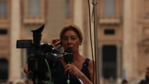 woman in red shirt holding black microphone