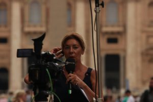 woman in red shirt holding black microphone