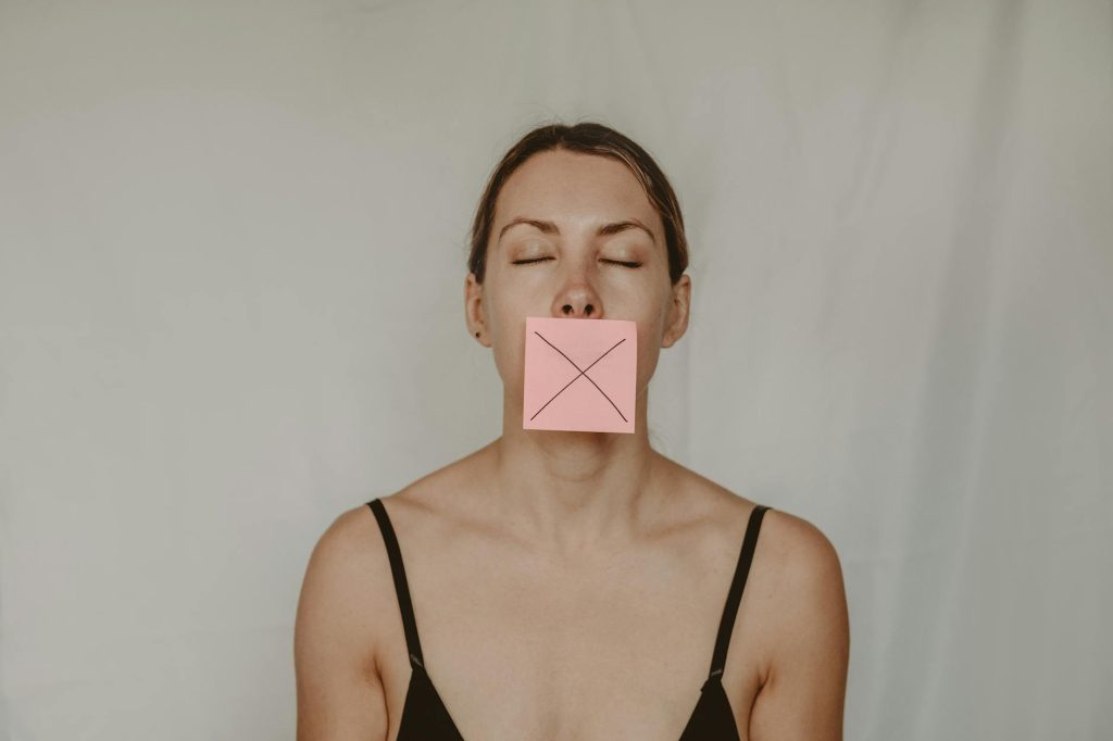 young woman with sticker showing cross on mouth