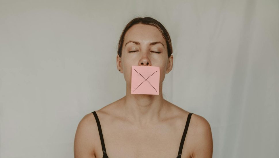 young woman with sticker showing cross on mouth