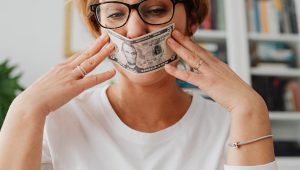 woman holding dollar against her face
