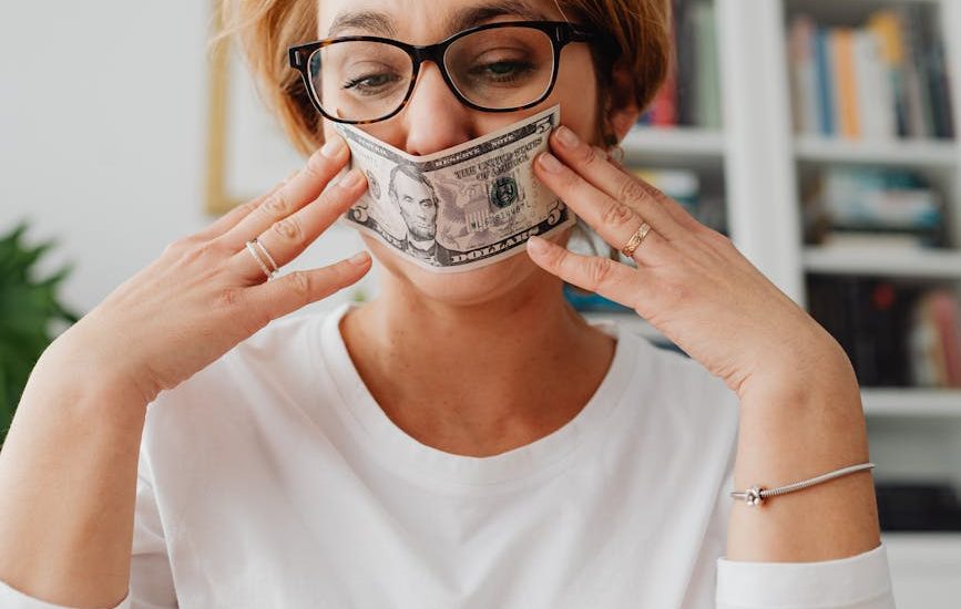 woman holding dollar against her face