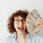 happy woman in blue long sleeve blouse holding money