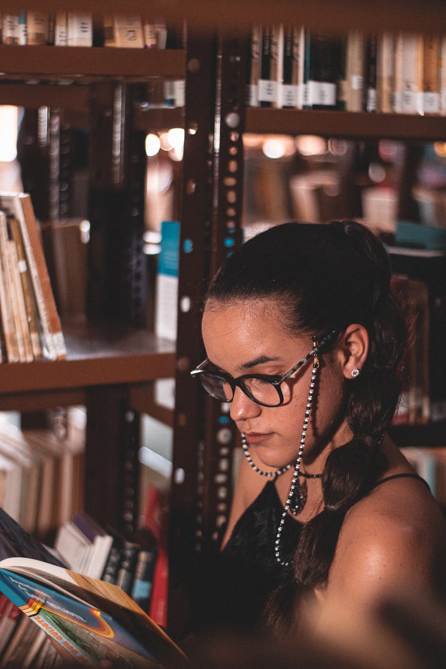 a woman with eyeglasses reading a book